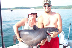 Karen is holding a 70 lb catfish, they fished with Norfork lake guide service STR Outfitters